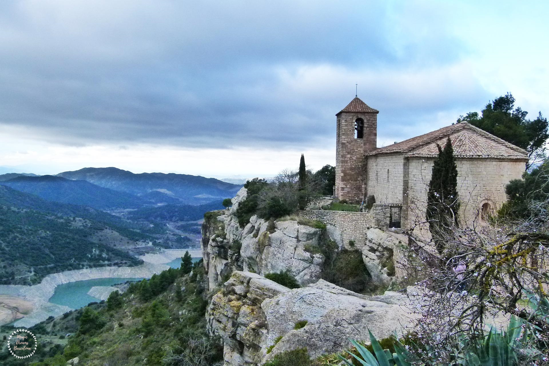 Detalle del campanario de Iglesia de Santa María en Siurana con el embalse de fondo.